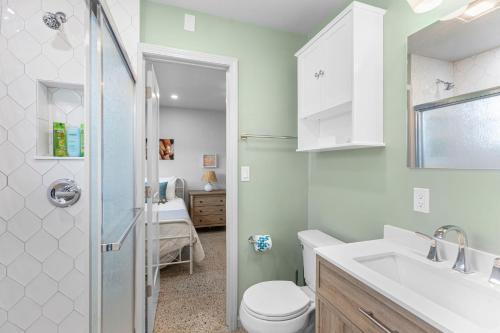 a bathroom with a toilet and a sink and a shower at Neptunes Hideaway in Vero Beach