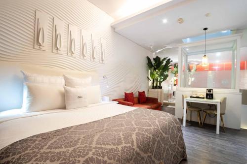 a bedroom with a large bed and a red chair at 168 Motel-Taoyuan in Taoyuan