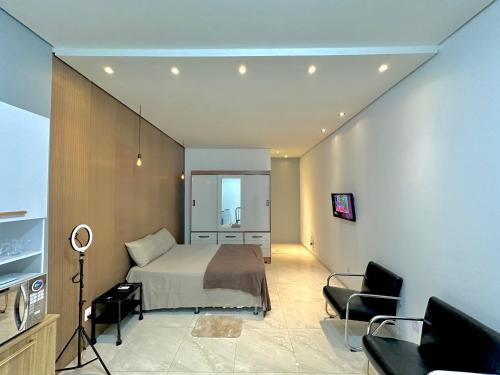 a bedroom with a bed and a living room at Garagem, Pátio Privativo - Apartamento Completo Moderno in Campo Novo do Parecis