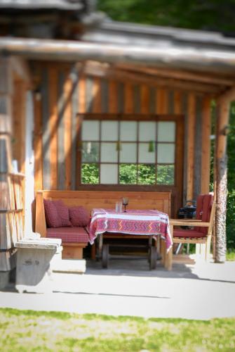 a patio with a table and a bench and a house at Obiralmhütte Meierhof in Bad Eisenkappel