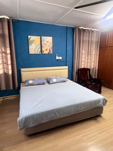 a bedroom with a bed with a blue wall at Harmoni Group Stay in Bintulu
