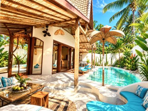 a villa with a swimming pool and a resort at Kaleydo Villas in Gili Trawangan