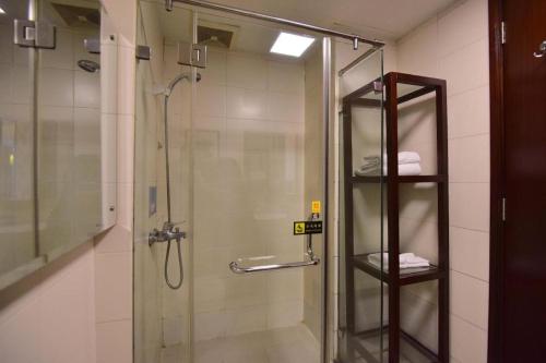 a shower in a bathroom with a glass door at Wanyi Hotel in Dongguan