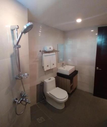 a bathroom with a white toilet and a sink at Hotel Asuncion in Laoag