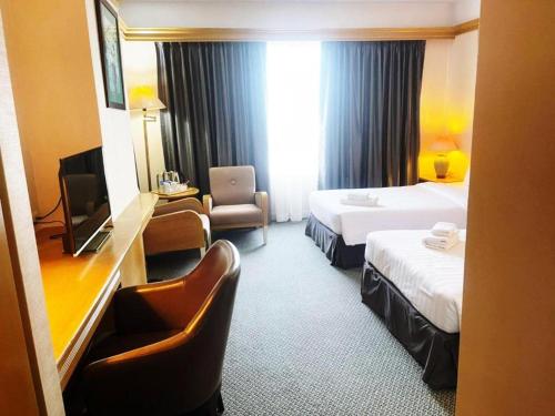 a hotel room with two beds and a television at Valaya Hotel Pathumthani in Ban Khlong Nung (1)