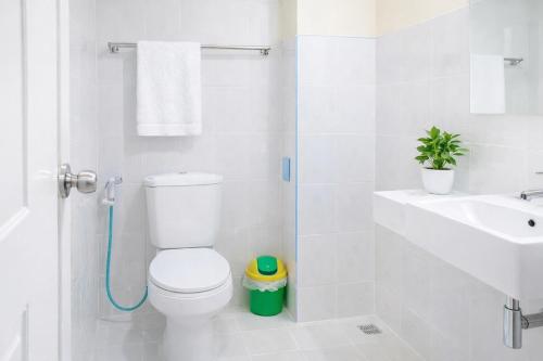 a white bathroom with a toilet and a sink at Pailin Hotel Krabi in Klong Muang Beach