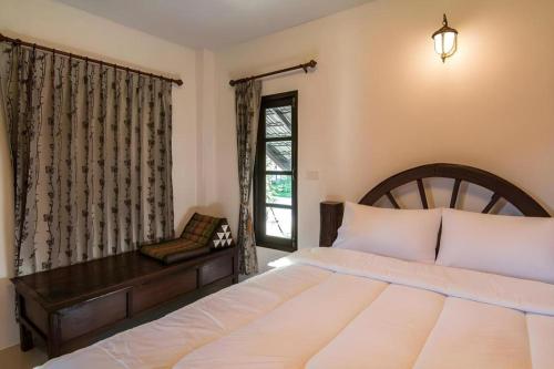 a bedroom with a large bed and a window at Tong Hotel in Ban Nong Chik