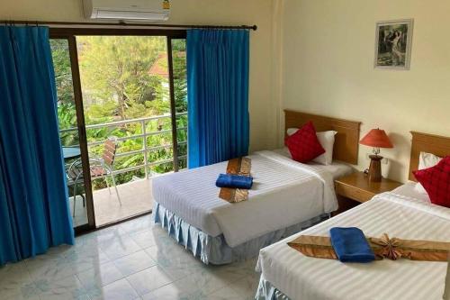 a hotel room with two beds and a balcony at Pailin Hotel Krabi in Klong Muang Beach
