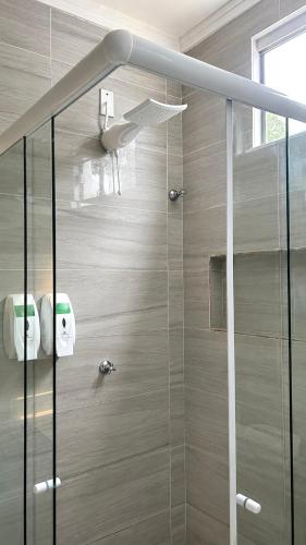 a shower with a glass door in a bathroom at Pousada Coco Babaçu in Viçosa do Ceará