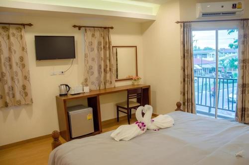 a room with a bed with a desk and a window at The Vintage Residence in Ban Thung Sukla