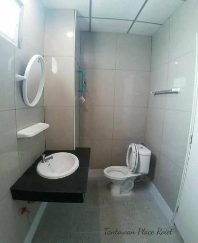 a bathroom with a toilet and a sink at Tantawan Place in Roi Et