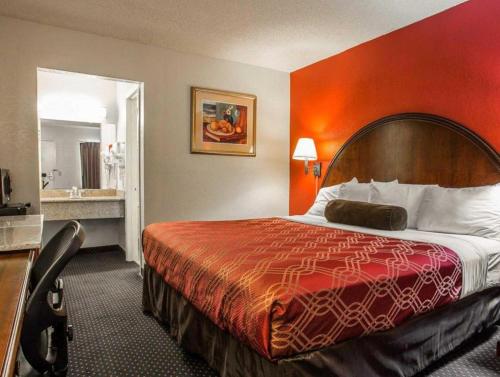 a hotel room with a bed and a bathroom at Econo Lodge Columbia Fort Jackson in Burnside East