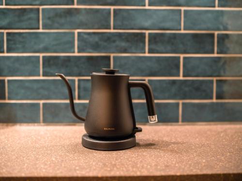 a black kettle sitting on a counter in a kitchen at SHIFT HOTEL Shibuya Jinnan in Tokyo