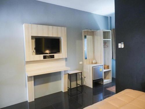 a bedroom with a tv on a wall at The Nest Hotel in Sathani Phu Khao Lat
