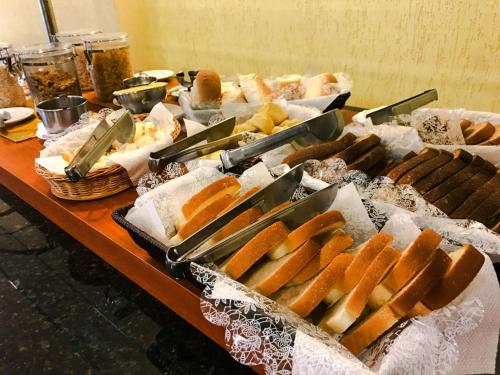 a buffet of hot dogs and pastries on a table at Rede Andrade Mercado Hotel in Curitiba