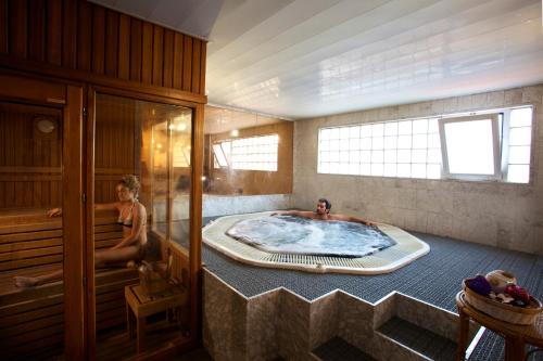 2 personas en una bañera de hidromasaje en una habitación en Hotel Domo, en Vilafranca del Penedès