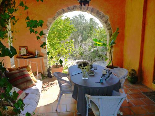 a patio with a table and chairs and an archway at L'Ostal du Pic St Loup in Saint-Jean-de-Cuculles