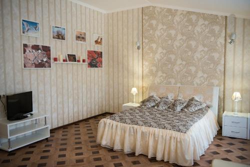 a bedroom with a bed and a flat screen tv at Guest House Bellagio in Tolyatti