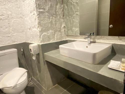 a bathroom with a white sink and a toilet at Southern View Hotel Pattani in Ban Ru Sa Mi Lae