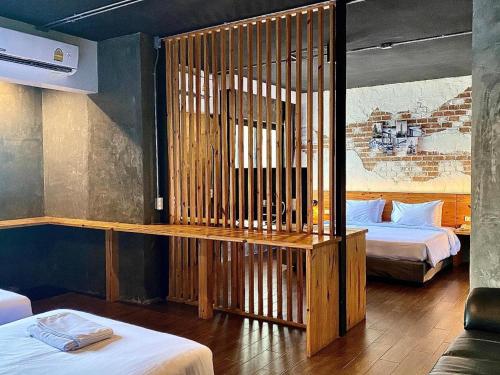 a room with two beds and a wooden partition at Southern View Hotel Pattani in Ban Ru Sa Mi Lae