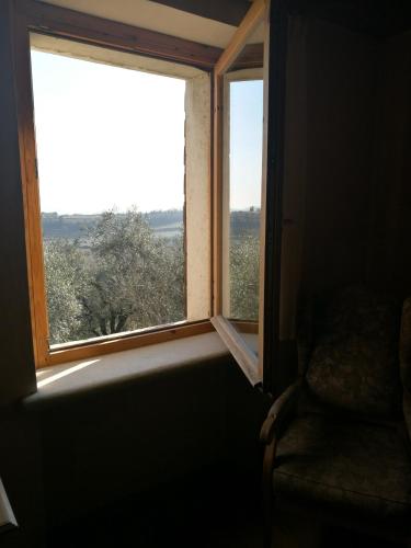 a window in a room with a chair and a view at Costa degli Ulivi in Fumane