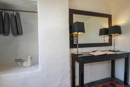 a bathroom with a mirror and a duck on a counter at Rock House in Tintagel