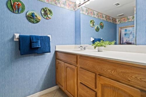 a bathroom with a white sink and blue walls at Boardwalk 201 in Cocoa Beach