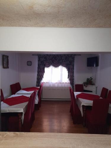 a room with four tables and chairs and a window at Cabana Dory și Dan in Arieşeni