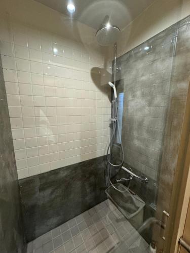 a shower in a bathroom with a glass door at Bunagaya in Ujimi