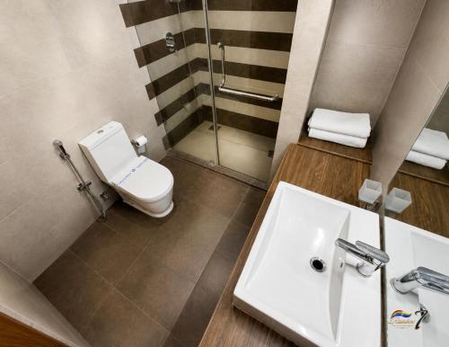 a bathroom with a toilet and a sink at Rainbow Seven Hotel in Negombo