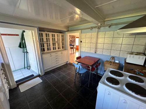 a kitchen with a stove and a table in it at Cozy Older Property On Ærø in Søby