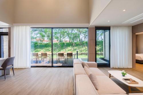 a living room with a couch and a table at The Brighton Hamdeok in Jeju