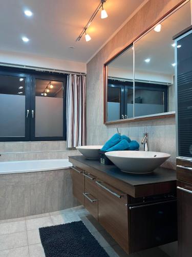 a bathroom with two sinks and a tub at Modernes City Apartment 8km Red Bull Ring in Knittelfeld