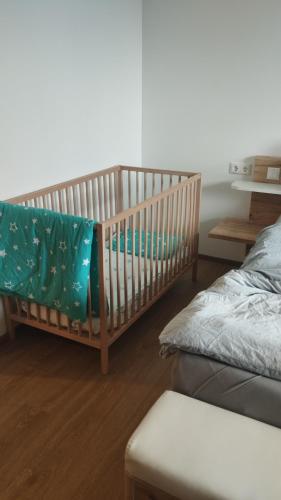 a crib in a room with a bed and a table at Ferienwohnung Steger in Mattsee
