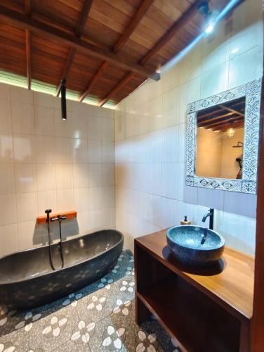 a bathroom with a large tub and a sink at Bukit Luah Sidemen in Sidemen