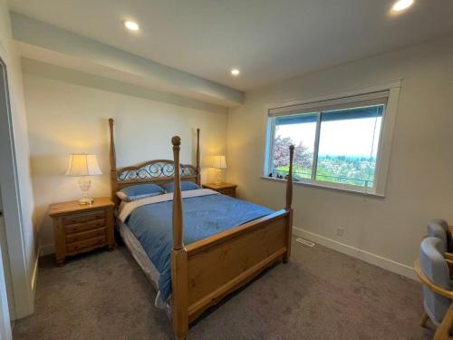 a bedroom with a wooden bed and a window at Sea view villa independent access in Nanaimo