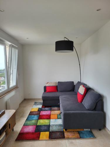 a living room with a couch and a colorful rug at Les Oyats in Équihen-Plage