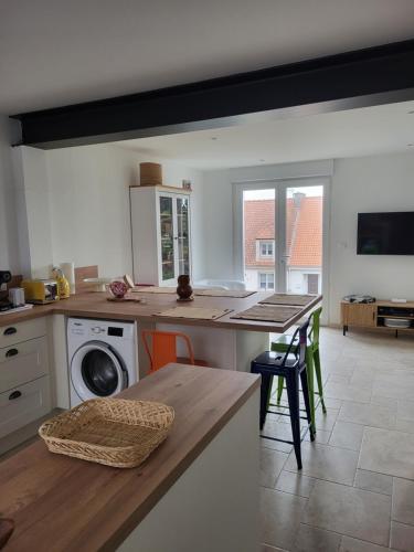 a kitchen with a counter and a table with chairs at Les Oyats in Équihen-Plage