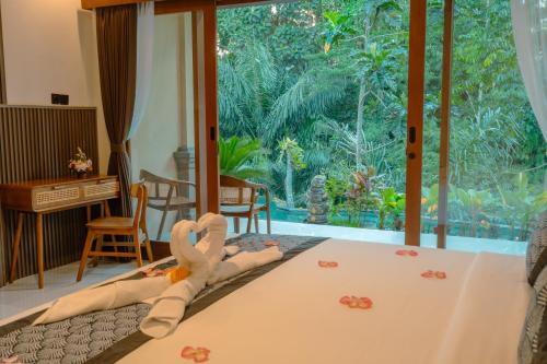 a room with a bed with a large window at Arcana Ubud in Ubud