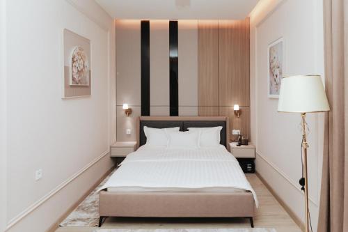 a bedroom with a bed and a lamp in it at Leore Hotel in Namangan