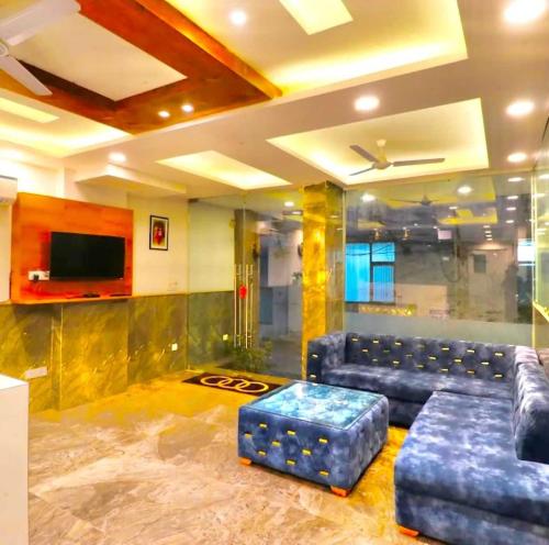 a living room with a couch and a tv at Hotel O Avi Suites in New Delhi