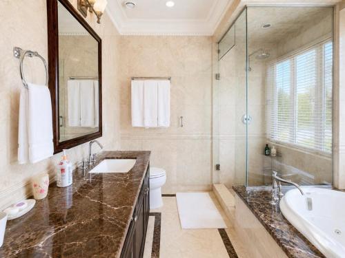 a bathroom with a sink and a toilet and a mirror at Campus Haven Near YVR UBC Downtown in Vancouver