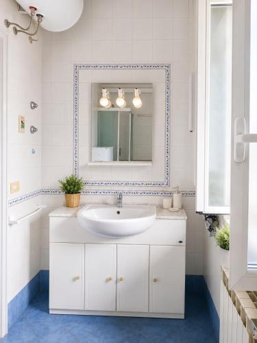 a white bathroom with a sink and a mirror at Casa Giusto Ischia in Ischia Town
