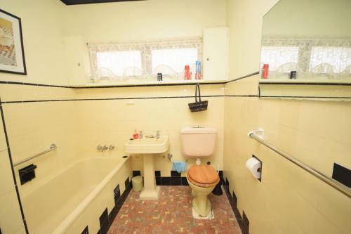 a bathroom with a toilet and a tub and a sink at 13 High Street in Nambucca Heads