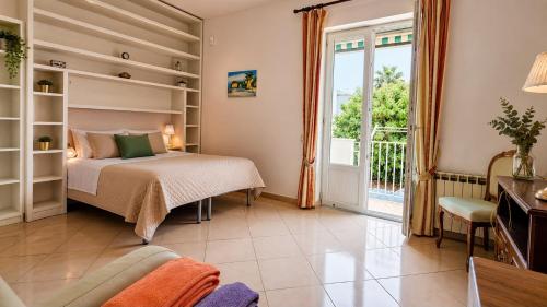 a bedroom with a bed and a sliding glass door at Casa Giusto Ischia in Ischia Town