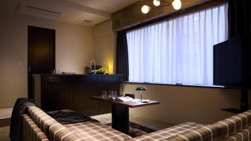 a room with a couch and a table and a window at SHIFT HOTEL Shibuya Jinnan in Tokyo