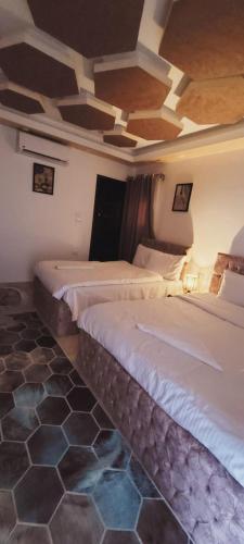 a bedroom with two beds and a coffered ceiling at Pyramids Aladdin Power in Cairo