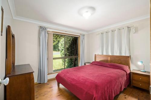 a bedroom with a bed and a large window at Coastal Charm in Valla Beach