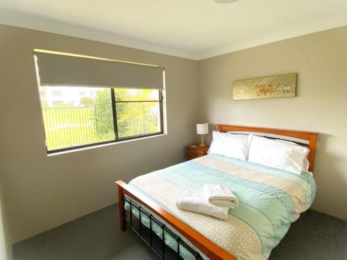 a bedroom with a bed with towels on it at Karingal in Nambucca Heads