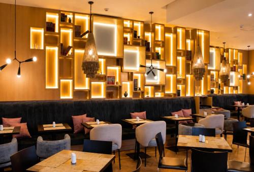 a restaurant with tables and chairs and a large chandelier at Wyndham Bogota in Bogotá